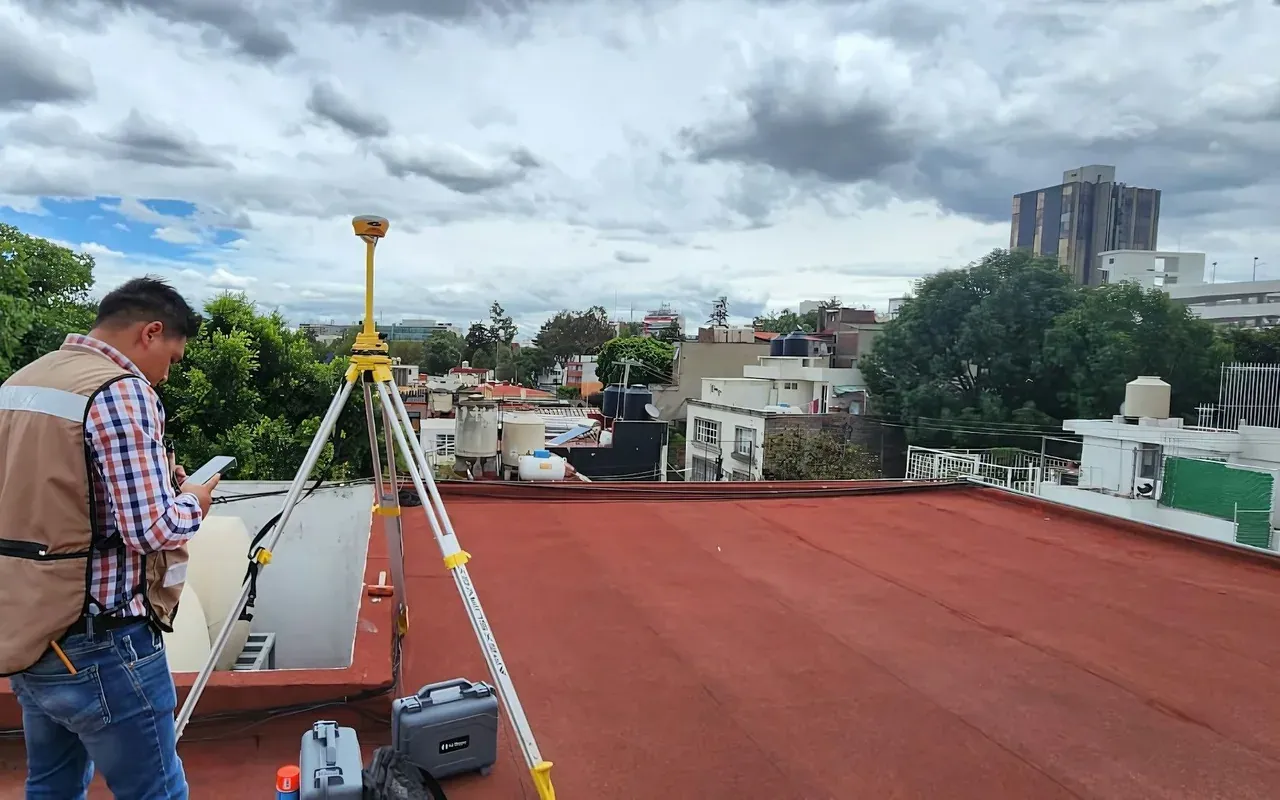 Surveyor with a tripod and tablet measuring a flat terrace